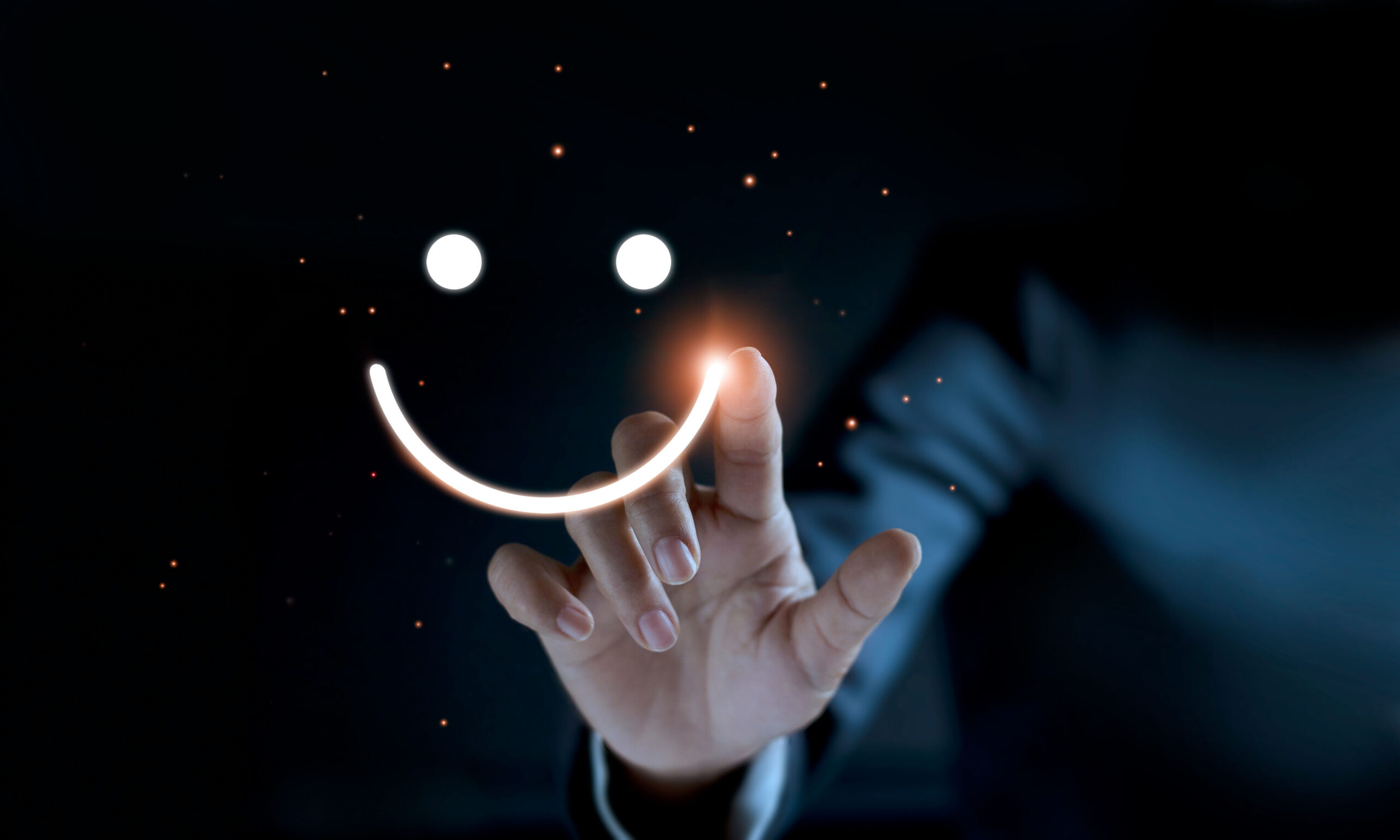 Finger of businessman touching and drawing face emoticon smile on dark background, service mind, service rating. satisfaction and customer service concept.